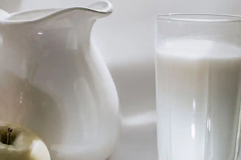 Beyaz bir sürahi ve sütle dolu bir bardak